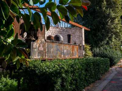 Dopo pochi metri, notiamo sulla sinistra una siepe e dei folti alberi: ed � proprio qui, quasi nascosta in questo scenario verdeggiante e accolta in un angolo realizzato con dei blocchi di pietra, che si trova la vecchia locomotiva